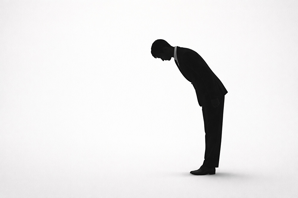 礼服姿で一礼する男性のシルエット。お悔やみの言葉のマナーを表すイメージ